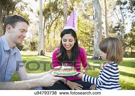Portrait of happy family in park celebrating mother's birthday View Large Photo Image Stock Photo - Portrait of happy family in park celebrating mother's birthday. Fotosearch