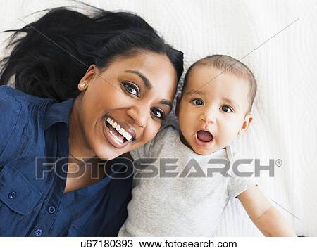 Portrait of happy mother with baby boy (2-5 months) making funny face View Large Photo Image Stock Image - Portrait of happy mother with baby boy (2-5 months) making funny face. Fotosearch