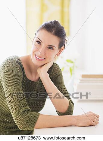 Portrait of happy woman sitting at table View Large Photo Image Stock Image - Portrait of happy woman sitting at table. Fotosearch
