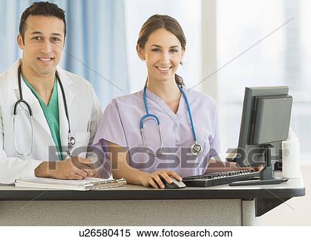 Portrait of male and female nurses at nurse's station in hospital View Large Photo Image Stock Photography - Portrait of male and female nurses at nurse's station in hospital. Fotosearch