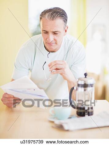 Portrait of man at kitchen table View Large Photo Image Stock Photo - Portrait of man at kitchen table. Fotosearch