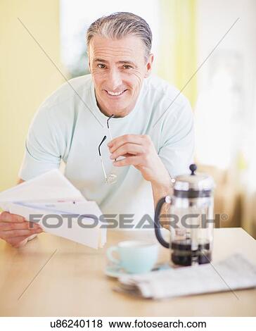 Stock Photo - Portrait of man at kitchen table. Fotosearch