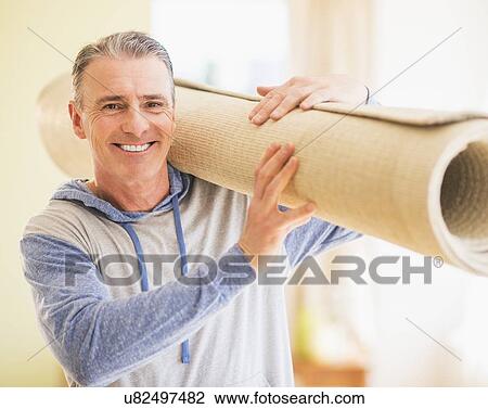 Portrait of man carrying folded carpet View Large Photo Image Stock Image - Portrait of man carrying folded carpet. Fotosearch