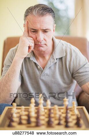 Portrait of man concentrating during chess game View Large Photo Image Stock Photo - Portrait of man concentrating during chess game. Fotosearch