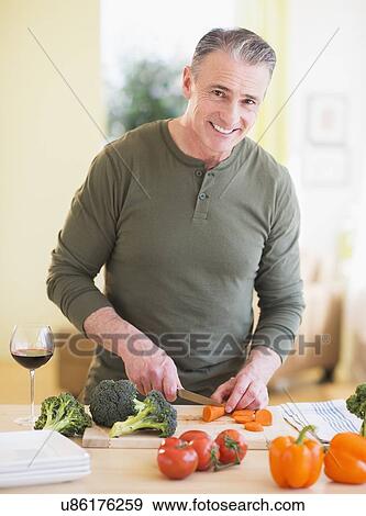 Portrait of man cutting vegetables View Large Photo Image Stock Photo - Portrait of man cutting vegetables. Fotosearch