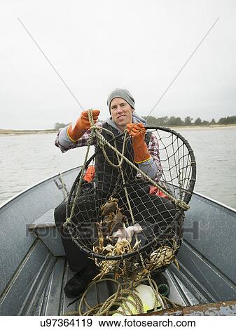 Stock Photo - Portrait of man holding crabs in net. Fotosearch