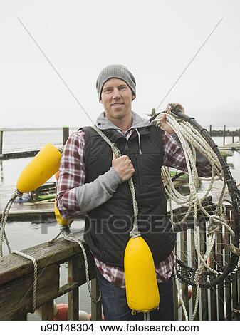Portrait of man holding fishing equipment View Large Photo Image Picture - Portrait of man holding fishing equipment. Fotosearch