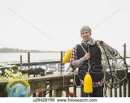 Portrait of man holding fishing equipment View Large Photo Image Stock Photo - Portrait of man holding fishing equipment. Fotosearch