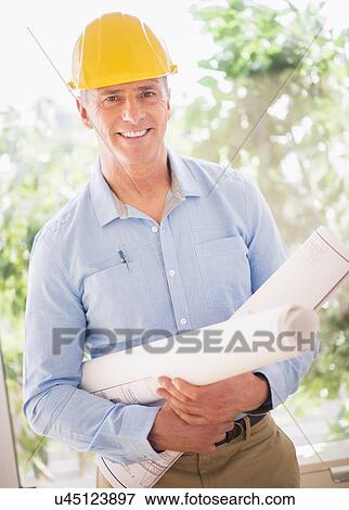 Portrait of man in hardhat holding rolled up blueprints View Large Photo Image Stock Photo - Portrait of man in hardhat holding rolled up blueprints. Fotosearch