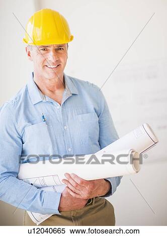 Portrait of man in hardhat holding rolled up blueprints View Large Photo Image Stock Photography - Portrait of man in hardhat holding rolled up blueprints. Fotosearch