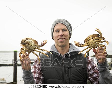 Stock Image - Portrait of man showing crabs. Fotosearch