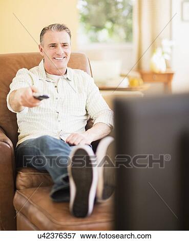 Portrait of man watching tv View Large Photo Image Stock Photo - Portrait of man watching tv. Fotosearch