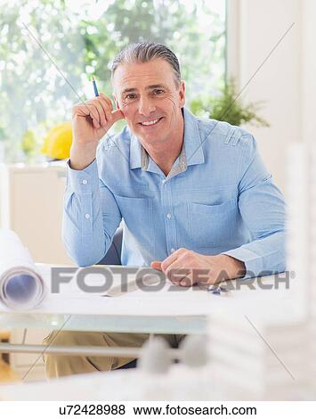 Portrait of man working in office View Large Photo Image Stock Photo - Portrait of man working in office. Fotosearch