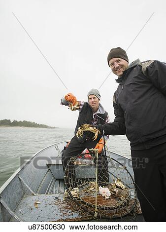 Stock Image - Portrait of men showing crabs. Fotosearch
