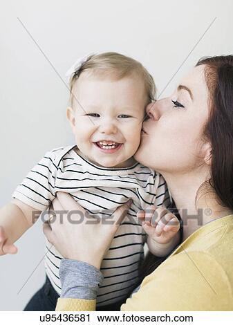 Portrait of mother kissing her daughter (12-17 months) View Large Photo Image Stock Image - Portrait of mother kissing her daughter (12-17 months). Fotosearch