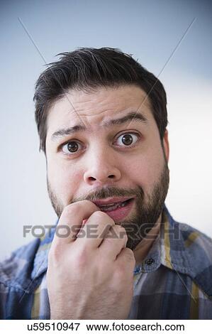 Stock Photo - Portrait of nervous man biting nail. Fotosearch