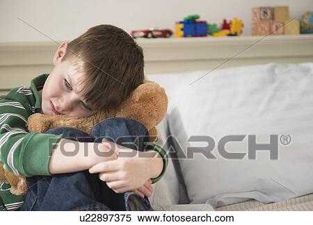 Portrait of sad boy (4-5) snuggling teddy bear View Large Photo Image Stock Photography - Portrait of sad boy (4-5) snuggling teddy bear. Fotosearch