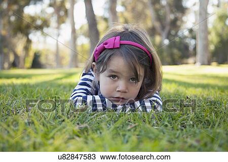 Portrait of sad girl (4-5 years) lying on grass in park View Large Photo Image Stock Image - Portrait of sad girl (4-5 years) lying on grass in park. Fotosearch