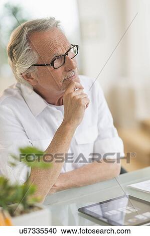 Portrait of senior man thinking at desk View Large Photo Image Stock Image - Portrait of senior man thinking at desk. Fotosearch