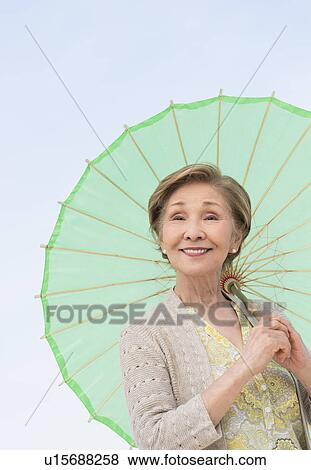 Portrait of senior woman holding green parasol View Large Photo Image Stock Photo - Portrait of senior woman holding green parasol. Fotosearch