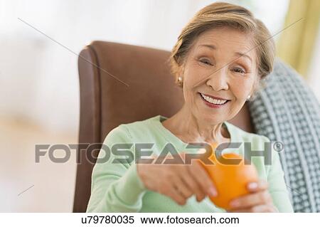 Portrait of senior woman peeling orange View Large Photo Image Stock Photography - Portrait of senior woman peeling orange. Fotosearch