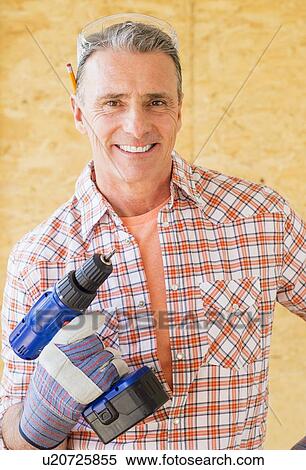 Portrait of smiling manual worker holding power tool View Large Photo Image Stock Photography - Portrait of smiling manual worker holding power tool. Fotosearch