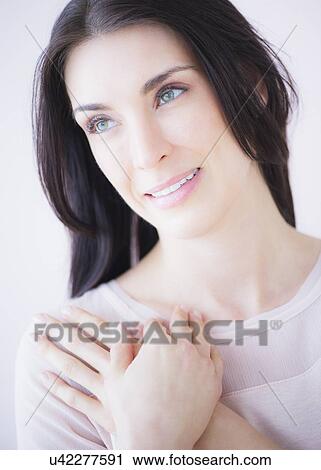 Stock Image - Portrait of smiling woman with arms crossed. Fotosearch