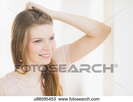 Portrait of smiling woman with hand in hair View Large Photo Image Stock Image - Portrait of smiling woman with hand in hair. Fotosearch