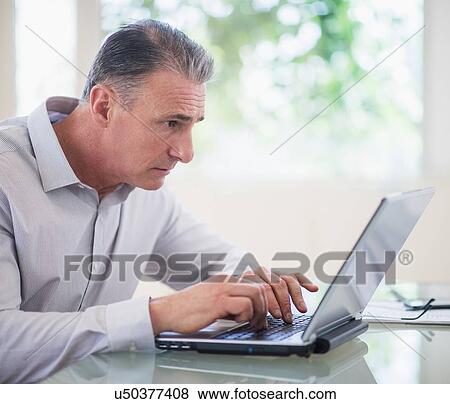 Stock Photo - Portrait of tired man working on laptop. Fotosearch