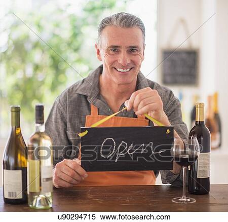 Portrait of wine store owner holding open sign View Large Photo Image Stock Photography - Portrait of wine store owner holding open sign. Fotosearch