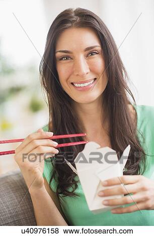 Stock Photo - Portrait of woman eating take out food. Fotosearch