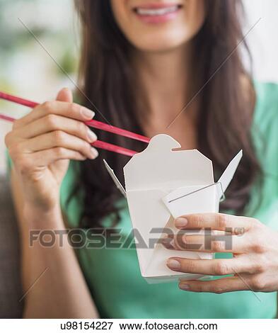 Stock Photo - Portrait of woman eating take out food. Fotosearch