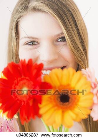 Stock Photo - Portrait of woman holding flowers. Fotosearch