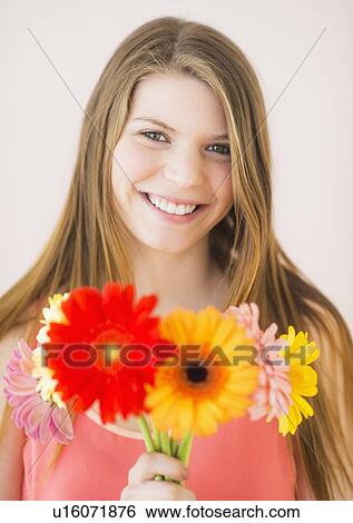 Stock Photograph - Portrait of woman holding flowers. Fotosearch