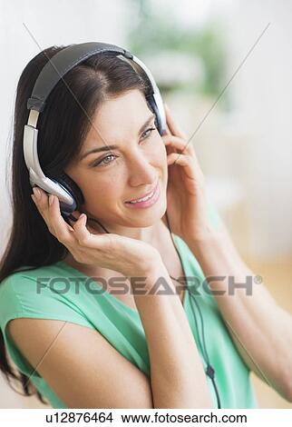 Portrait of woman listening to music on headphones View Large Photo Image Picture - Portrait of woman listening to music on headphones. Fotosearch