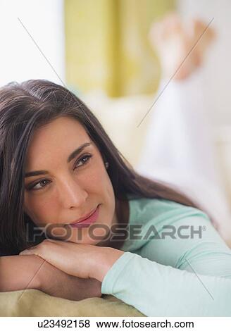Portrait of woman lying down on bed with hand on chin, Looking away, Close-up View Large Photo Image Stock Photo - Portrait of woman lying down on bed with hand on chin, Looking away, Close-up. Fotosearch