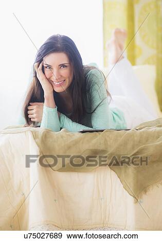 Portrait of woman lying down on bed with head in hands View Large Photo Image Stock Photo - Portrait of woman lying down on bed with head in hands. Fotosearch