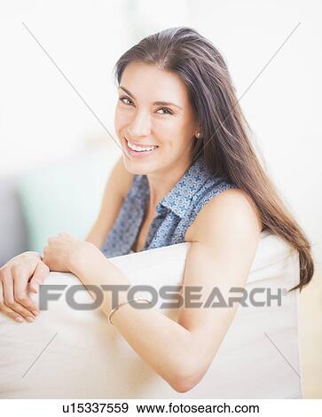 Stock Photo - Portrait of woman relaxing on sofa. Fotosearch