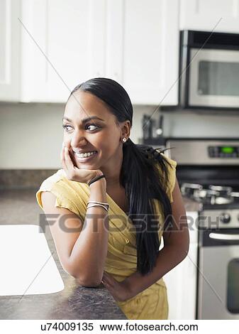 Stock Photography - Portrait of woman standing in kitchen. Fotosearch