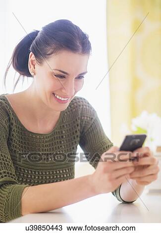 Stock Image - Portrait of woman using mobile phone. Fotosearch