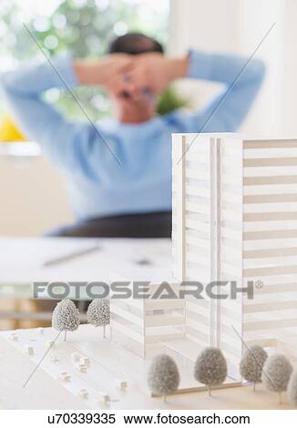 Stock Photography - Rear view of man sitting in office. Fotosearch
