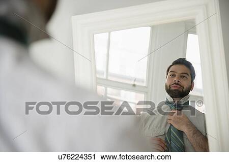 Reflection of man tying tie View Large Photo Image Stock Image - Reflection of man tying tie. Fotosearch