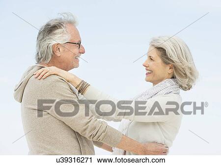 Stock Image - Senior couple embracing outdoors. Fotosearch