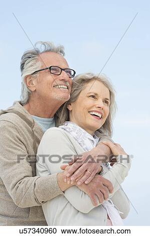Stock Image - Senior couple embracing outdoors. Fotosearch