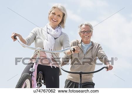 Senior couple riding bicycle View Large Photo Image Stock Image - Senior couple riding bicycle. Fotosearch