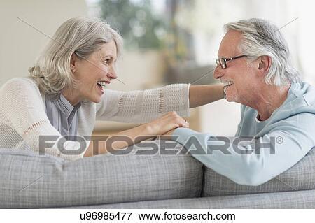 Senior couple sitting on sofa View Large Photo Image Stock Photo - Senior couple sitting on sofa. Fotosearch