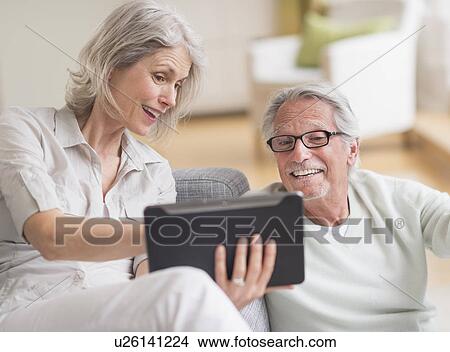 Senior couple using digital tablet at home View Large Photo Image Picture - Senior couple using digital tablet at home. Fotosearch