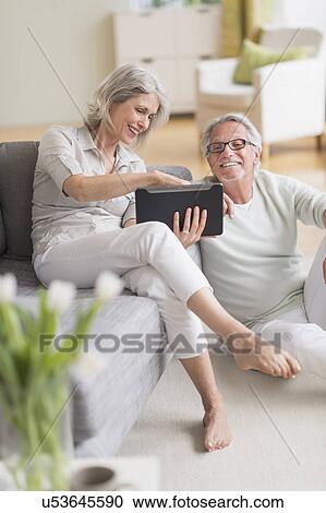 Stock Image - Senior couple using digital tablet at home. Fotosearch