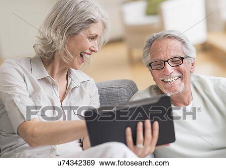 Senior couple using digital tablet at home View Large Photo Image Stock Photo - Senior couple using digital tablet at home. Fotosearch