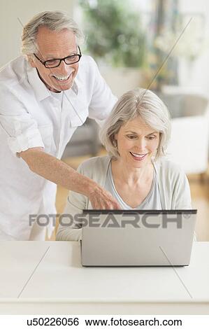 Stock Photograph - Senior couple using laptop. Fotosearch